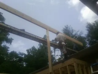 Carpenter setting a ridge beam over a new addition frame — Ice Dam Removal by Roofing Brothers in Stendal