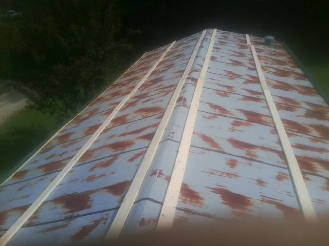 Rusted metal roof panels with new wood purlins before replacement — Storm Damage Roof Repair in Stendal by Roofing Brothers