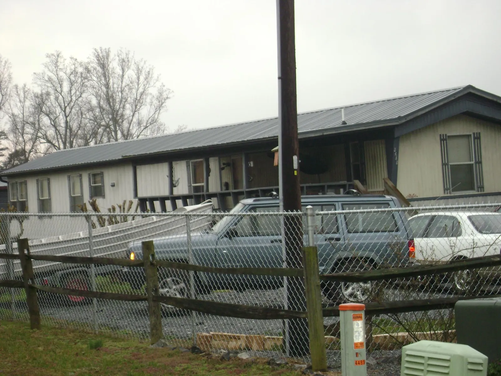 Dark metal roof on a long single story building behind a chain link fence in Stendal