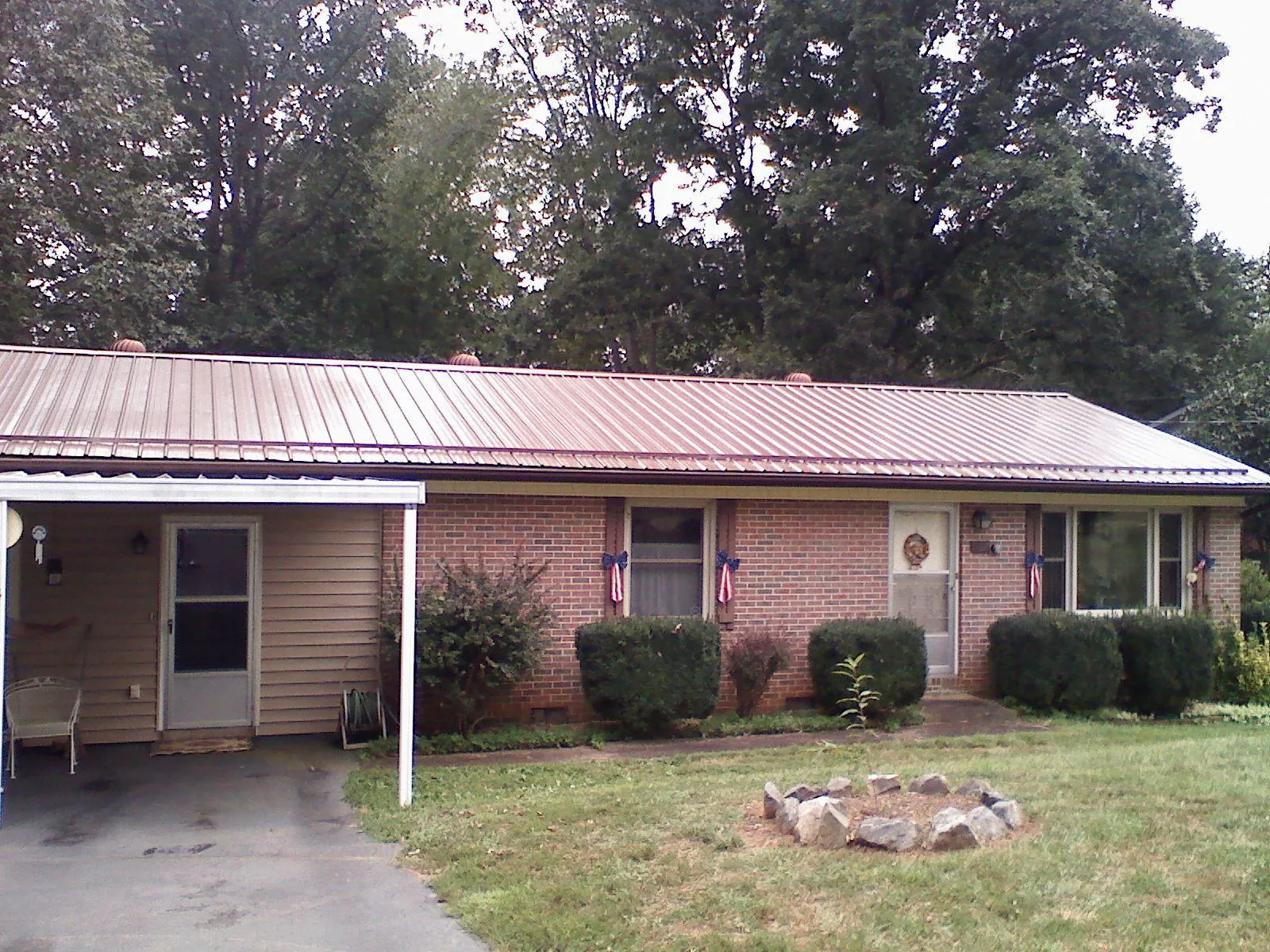 Bronze metal roof and carport on a brick ranch home — Roof Repair work by our crew in Stendal
